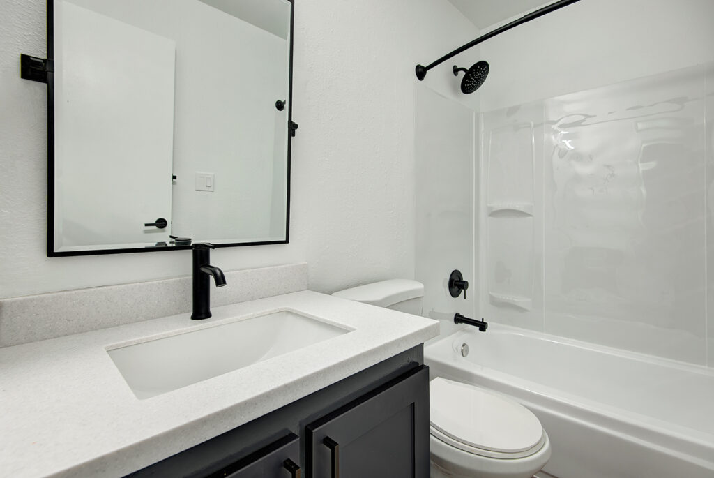 Bathroom with toilet, vanity, and tub shower at our apartments for rent in Everett, WA.