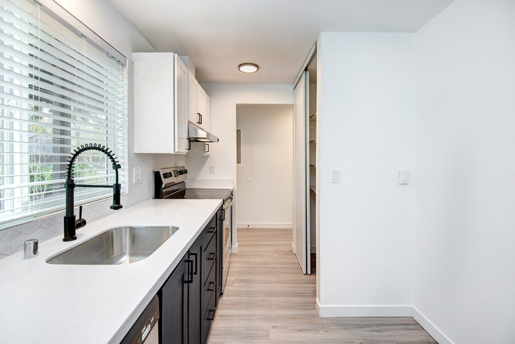 Kitchen with white countertops and a window above the sink in our apartments in Everett, WA.